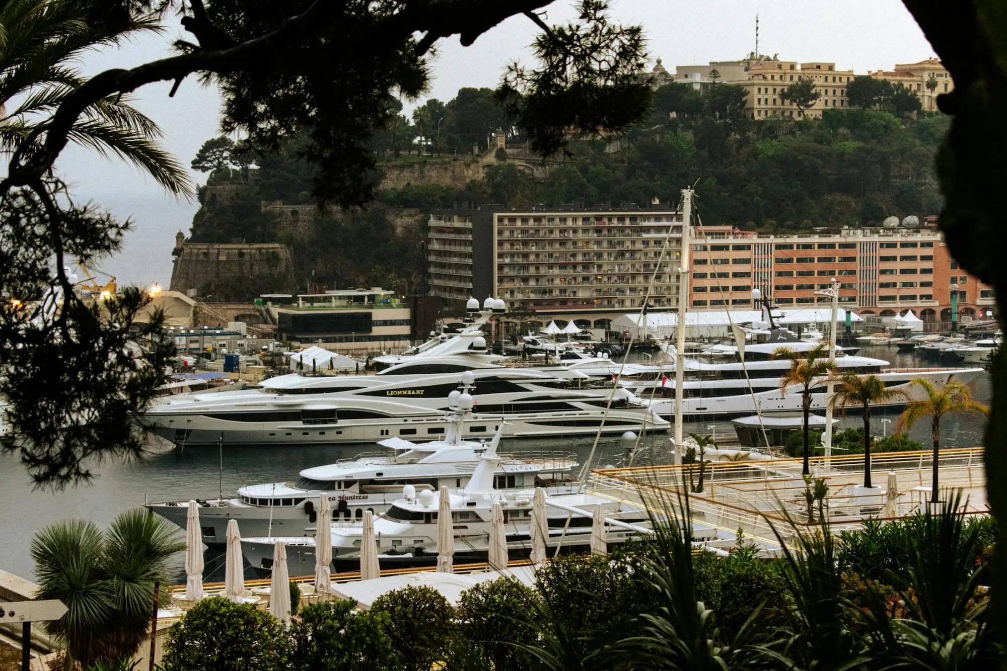 Superyachts moored in a Mediterranean harbour below a hillside town