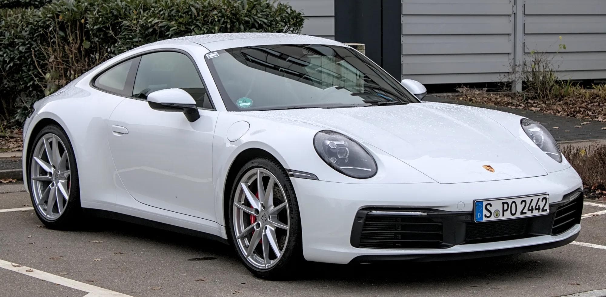 A 992-generation Porsche 911 Carrera S in white, photographed in front three-quarter view, the model line that rose 22 percent in deliveries during the first quarter of 2026